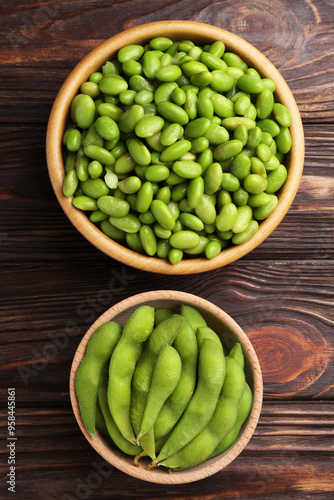 Raw green edamame soybeans and pods on wooden table, top view