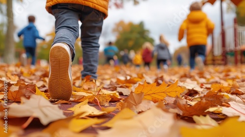 A child walks through colorful autumn leaves, capturing the essence of fall in a vibrant playground scene. photo