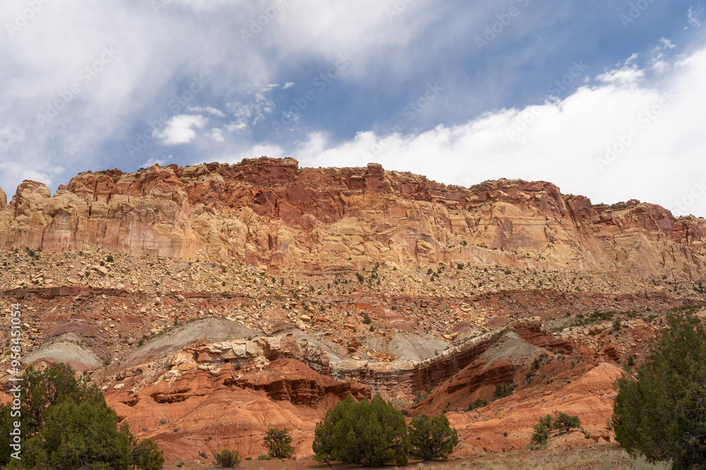 Fototapeta premium A cloudy and sunny view of red rocks at Capitol Reef National Park in Utah.