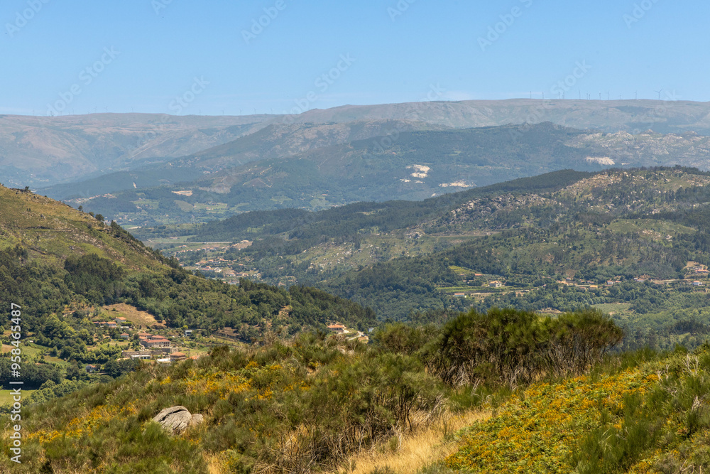 Naklejka premium Northern Portuguese landscape with green mountains and hills and a blue sky. In the Portuguese district of Braga near the town of Fafe.