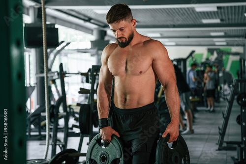 Muscular strong man is working out in the gym