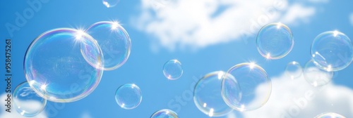 Transparent soap bubbles float gracefully in a clear blue sky with fluffy white clouds