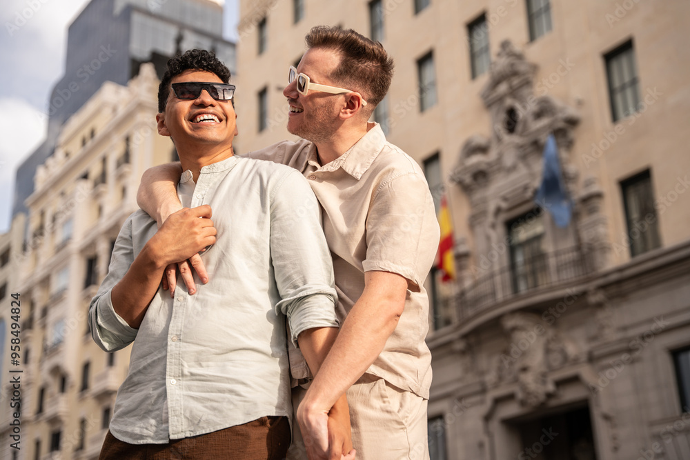 Multiethnic gay couple enjoying a walk in a city setting Multiethnic gay couple enjoying a walk in a city setting