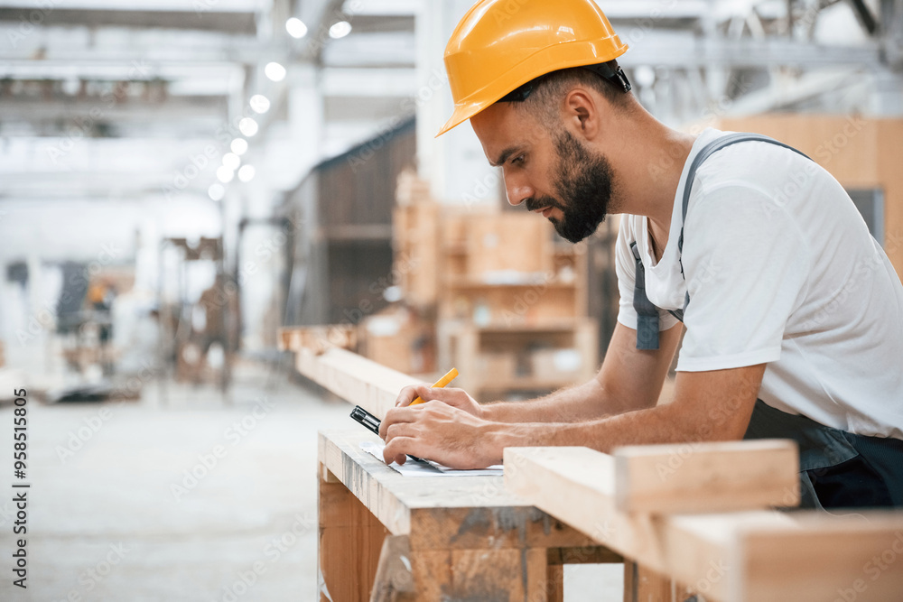 Yellow pen, marks the area. Industrial worker in wooden warehouse Yellow pen, marks the area. Industrial worker in wooden warehouse
