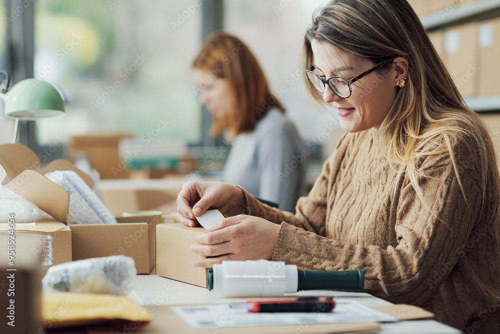 E-commerce employee sticking a label on a box E-commerce employee sticking a label on a box