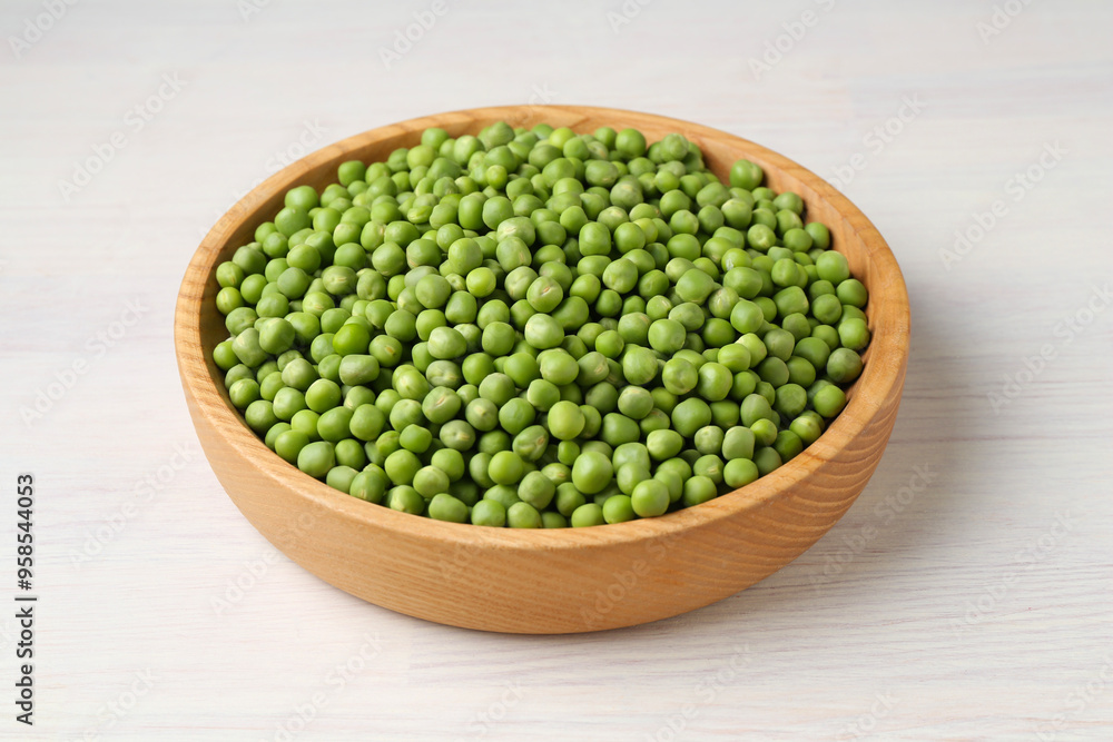 Fresh green peas in bowl on white wooden table, closeup Fresh green peas in bowl on white wooden table, closeup