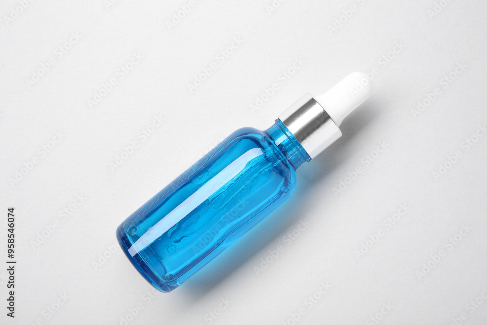 Essential oils in bottle on light background, top view Essential oils in bottle on light background, top view