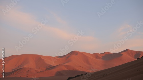 A view of the red desert mountains against a soft pink and blue sky.