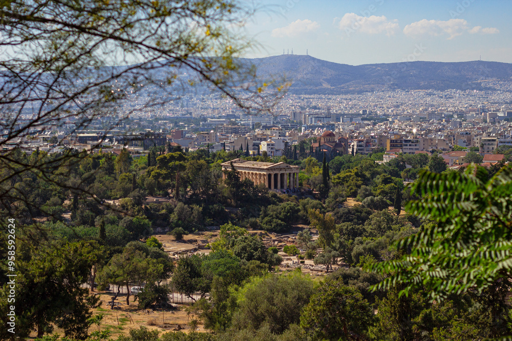 Obraz premium The ancient Greek temple of Hephaestus in ancient Agora in Athens as seen from the top of Acropolis hill in Greece