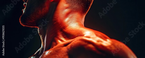 Close-up of a muscular neck showcasing defined muscles and an artistic light highlighting strength and fitness.