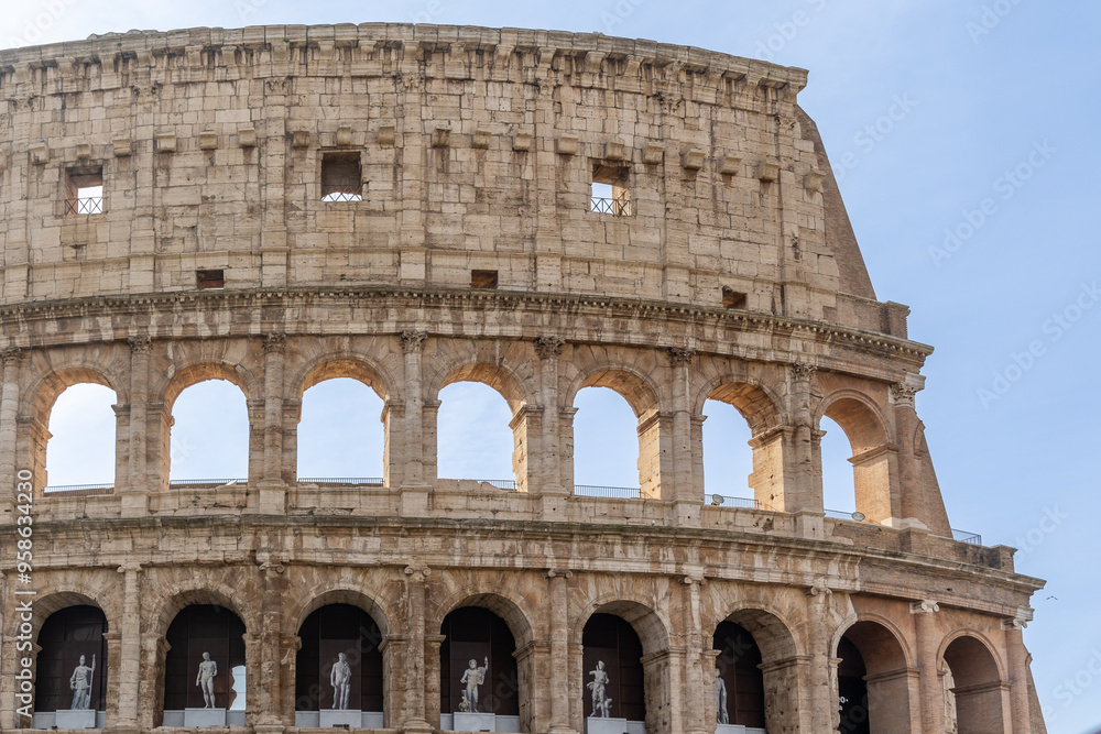 Obraz premium Rome, Italy - April 09, 2024: Ruins of the Coliseum with tourists strolling among the archaeological remains in Rome, Italy