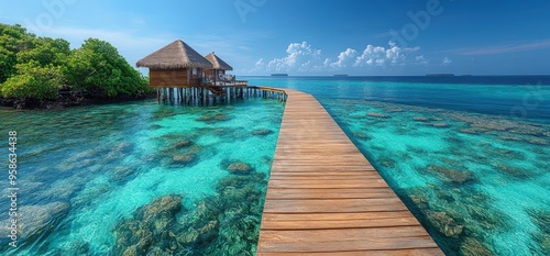 Wooden walkway leads to overwater bungalows on a tropical island. photo