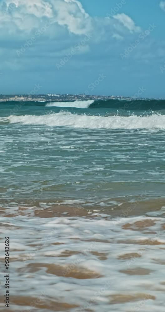 Vertical video, White foamy waves of turquoise sea cascade in shore background. Blue clear sky horizon over raging ocean water in sunny hot summer nature. Wide endless seascape side view landscape Vertical video, White foamy waves of turquoise sea cascade in shore background. Blue clear sky horizon over raging ocean water in sunny hot summer nature. Wide endless seascape side view landscape