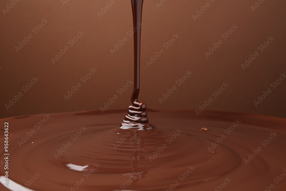 Pouring delicious melted chocolate on brown background, closeup Pouring delicious melted chocolate on brown background, closeup