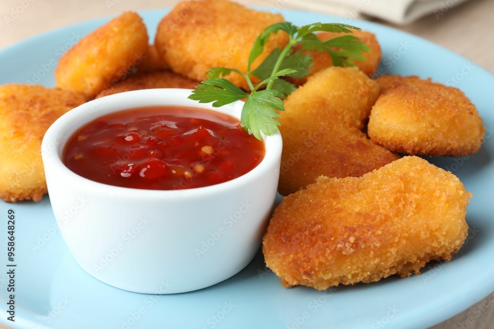 Tasty chicken nuggets with chili sauce and parsley on table, closeup Tasty chicken nuggets with chili sauce and parsley on table, closeup