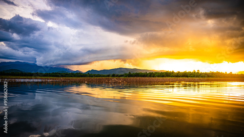 Evening sun rays with rain clouds forming over Thap Salao Dam, Uthai Thani Province, Thailand. photo