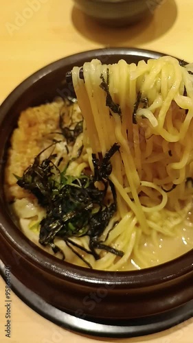 Hot ramen with noodles and delicious broth. The concept of Japanese noodles with fish and water. A man eats Asian noodles with chopsticks photo