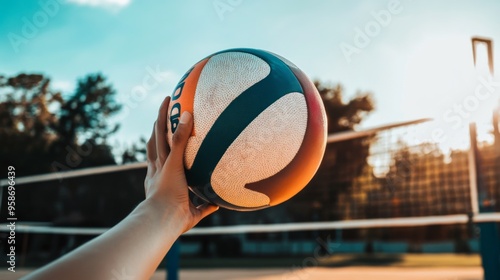 Hand Holding Volleyball Against Sunset Background