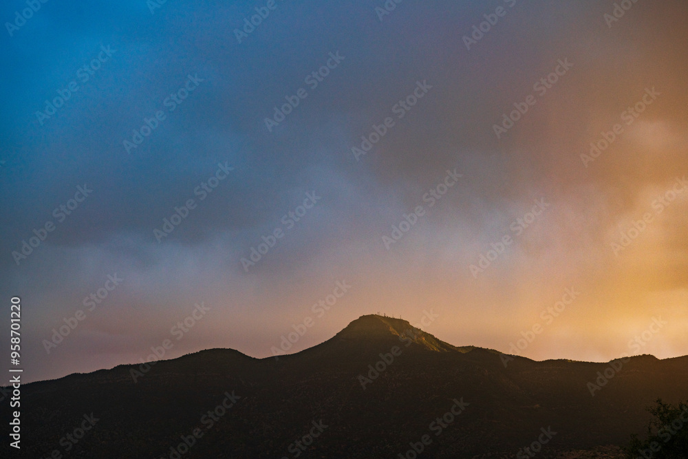 Sunset through dark storm clouds over mountains near Verde Valley, Arizona Sunset through dark storm clouds over mountains near Verde Valley, Arizona