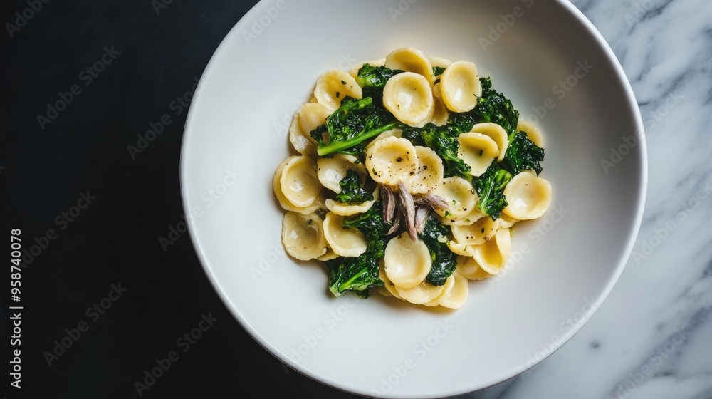 An artistic presentation of orecchiette pasta with broccoli rabe, anchovies, and garlic, served in a minimalist style. - An artistic presentation of orecchiette pasta with broccoli rabe, anchovies, and garlic, served in a minimalist style. -