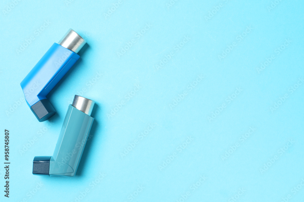 Asthma inhalers on light blue background, flat lay. Space for text Asthma inhalers on light blue background, flat lay. Space for text