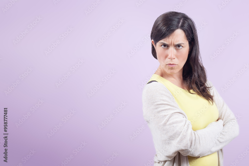 Woman with her arms crossed looks angrily at the camera. Concept of frustration and defiance. Woman with her arms crossed looks angrily at the camera. Concept of frustration and defiance.