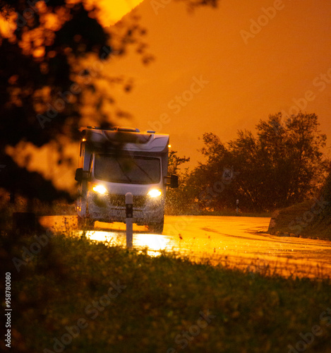 a caravan drive on the rainy road in orange sunset light. travel and van life concept