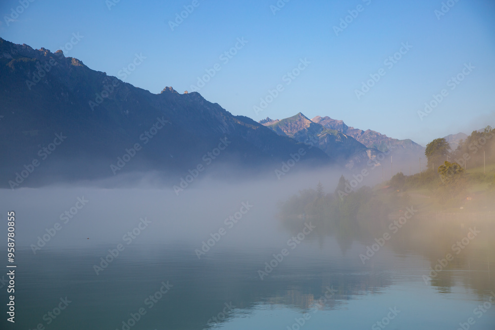 fog above a lake surrounded with mountains fog above a lake surrounded with mountains