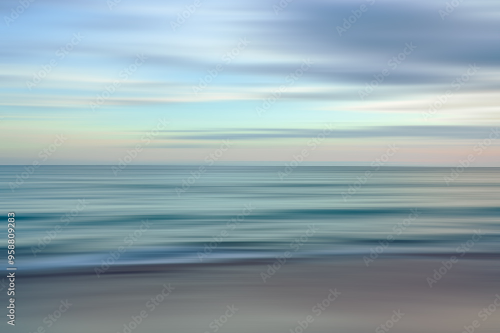 Ethereal waves flow in a blurred dance of blues and oranges in a serene seascape