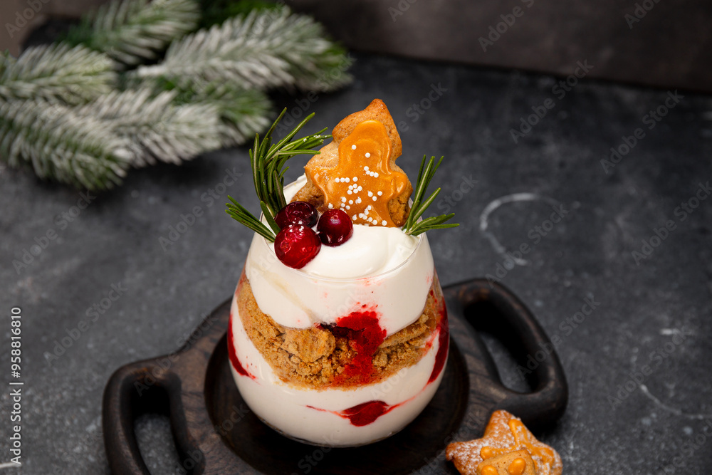 A glass of Christmas dessert with gingerbread cookies, whipped cream and cranberries on grey background A glass of Christmas dessert with gingerbread cookies, whipped cream and cranberries on grey background
