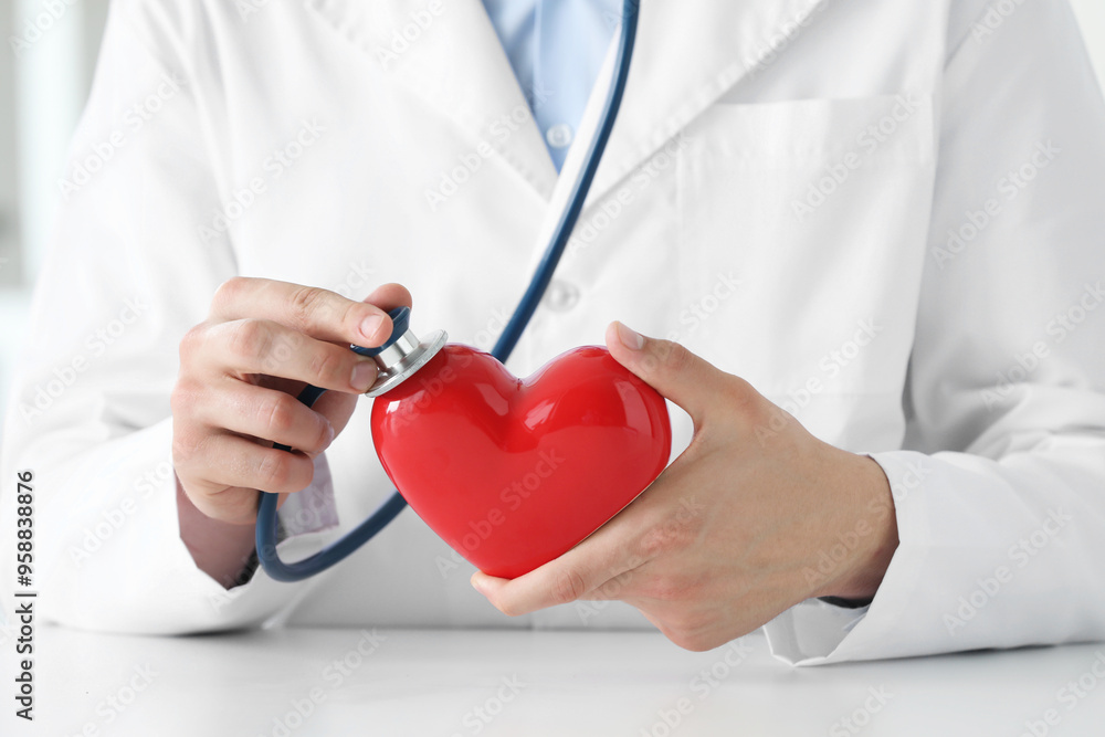 Doctor with stethoscope and red heart at white table, closeup Doctor with stethoscope and red heart at white table, closeup