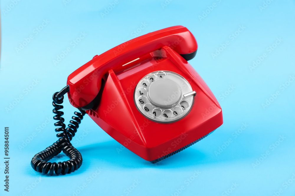 Red telephone with handset on light blue background Red telephone with handset on light blue background