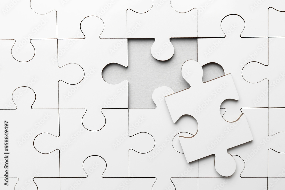 White puzzle with missing piece on grey background, top view White puzzle with missing piece on grey background, top view