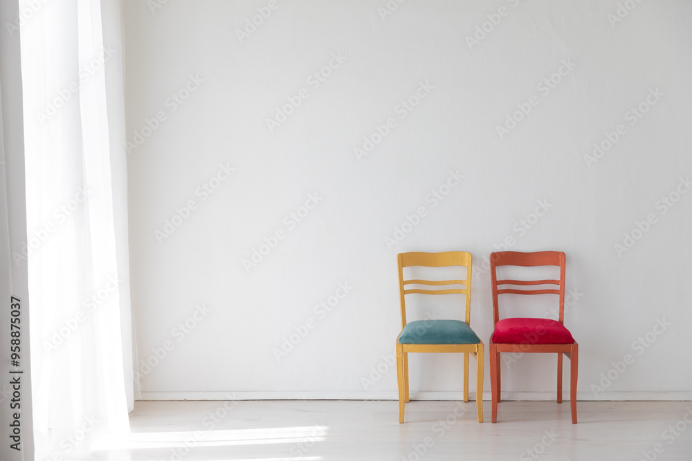 Fototapeta premium Two old vintage chairs in the interior of a white room near the wall