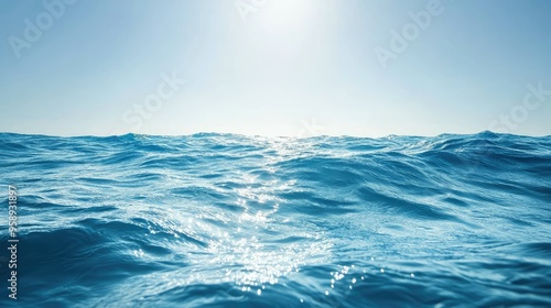 Deep blue ocean waves under a clear sky, sunlight reflecting on the water surface