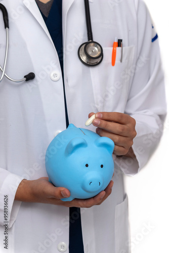 A doctor is holding a blue piggy bank and putting a pill in it