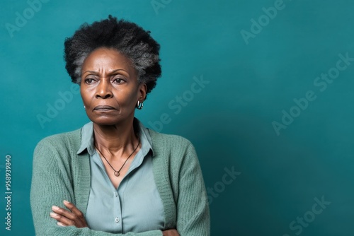 Teal background sad black American independent powerful Woman. Portrait of older mid-aged person beautiful bad mood expression girl Isolated on Background racism skin