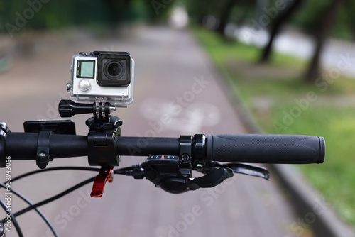 Modern action camera with mount on bicycle outdoors, closeup