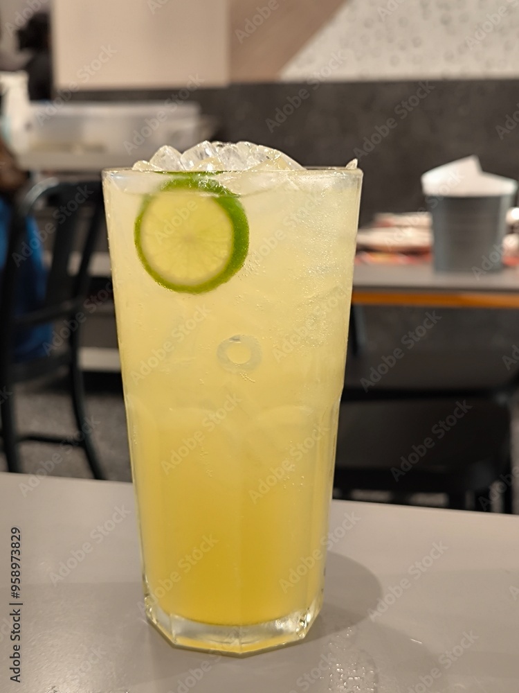 Iced honey lime soda in glass on table in restaurant. Lime juice. Lemonade. Beverage menu Iced honey lime soda in glass on table in restaurant. Lime juice. Lemonade. Beverage menu