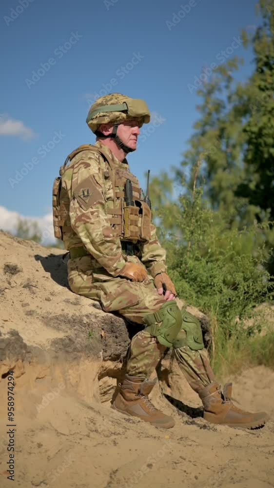 A soldier in a helmet, body armor and with a radio. Portrait of a soldier in full uniform. A soldier in a helmet, body armor and with a radio. Portrait of a soldier in full uniform.