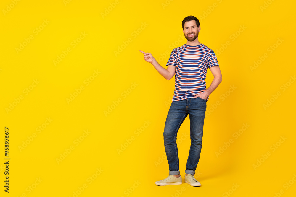 Full size photo of optimistic man dressed striped t-shirt indicating at offer empty space isolated on vibrant yellow color background Full size photo of optimistic man dressed striped t-shirt indicating at offer empty space isolated on vibrant yellow color background