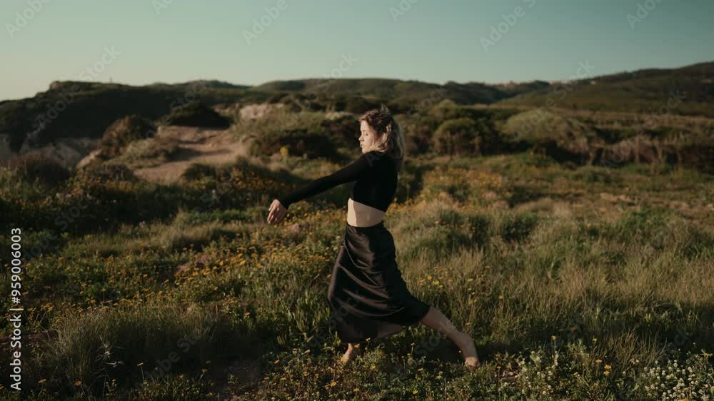 A full body length of a woman performing a conceptual dance in a beautiful, natural field with scenic landscapes in the background. A full body length of a woman performing a conceptual dance in a beautiful, natural field with scenic landscapes in the background.