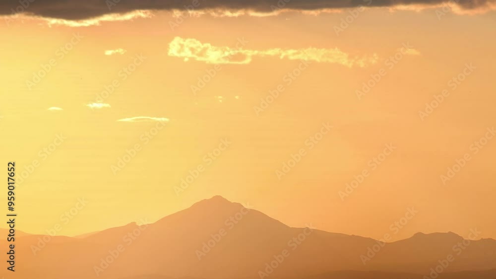 Time-lapse of the sun setting behind a mountain, perfect for endings and reflections with text space. Time-lapse of the sun setting behind a mountain, perfect for endings and reflections with text space.