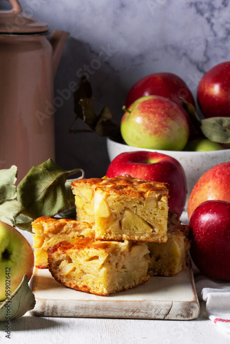 Apple pie, apples and teapot served for tea. Traditional apple dessert.