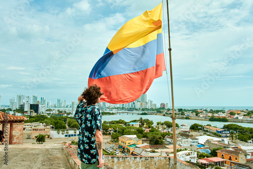 Man next to the flag of Colombia with Cartagena de Indias. photo