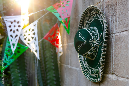 mexican mariachi hat hanging on a wall with decorative pennants