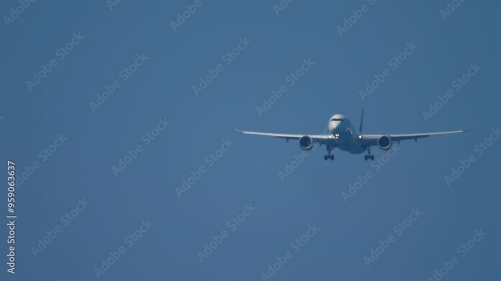 Aircraft with an unrecognizable livery is approaching for landing, bottom view. Airliner in the blue sky. Flight arrival. Air traffic Travel concept Aircraft with an unrecognizable livery is approaching for landing, bottom view. Airliner in the blue sky. Flight arrival. Air traffic Travel concept