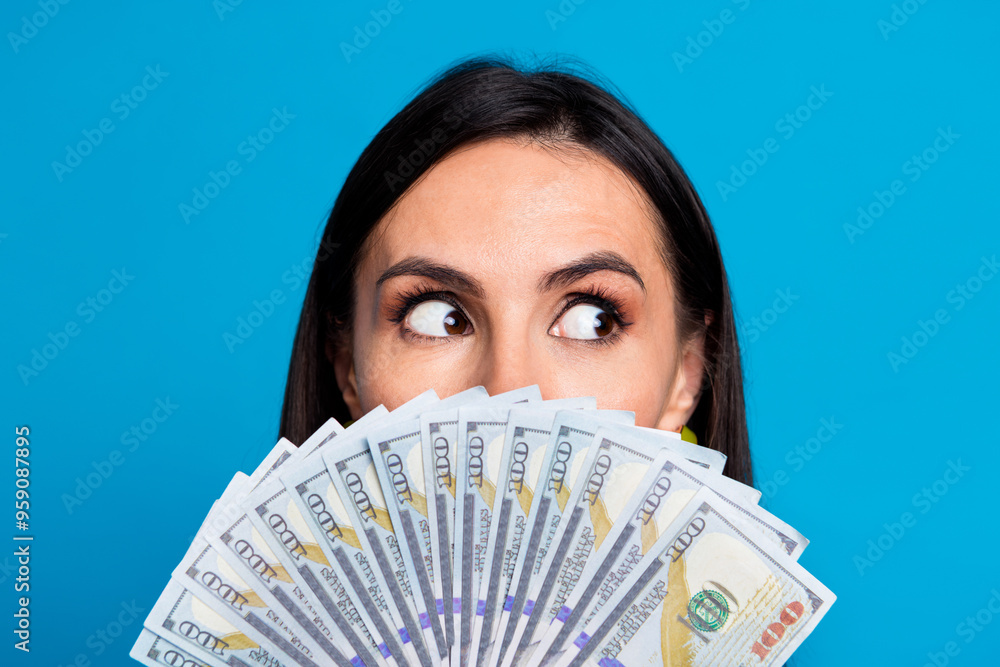 Close up photo of charming lovely funny woman wear trendy clothes showing money empty space isolated on blue color background Close up photo of charming lovely funny woman wear trendy clothes showing money empty space isolated on blue color background