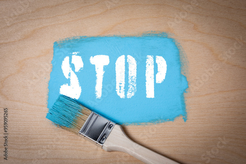 STOP. Blue paint and paint brush on wooden background photo