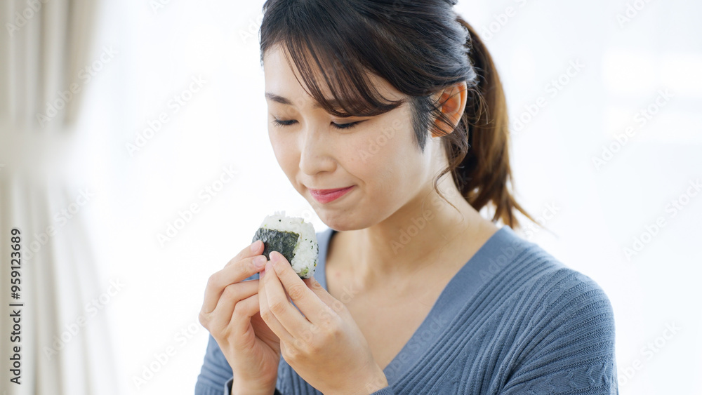 おにぎりを笑顔で食べる女性